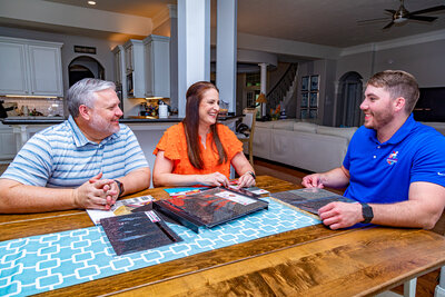 A Mighty Dog Roofing inspector reviewing roof shingle options with two homeowners at their dining room table